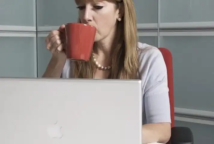 6-Mujer trabajando en su computador y tomando cafe