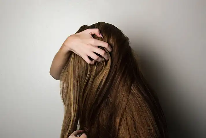 Chica agarrandose el cabello